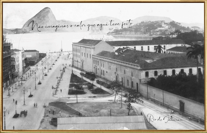 Cartão-postal em preto e branco do Rio de Janeiro. Pessoas transitam por uma avenida à esquerda, dividida por postes com adornos espiralados. Uma carruagem passa pela mesma avenida. Ao centro, uma praça triangular. À direita, um prédio largo de dois andares. Ao fundo, no mar e, mais ao longe, os morros. Sobre eles, está escrito, com a caligrafia de Oswaldo: “Não sabes o calor que aqui tem feito”. No canto inferior direito está escrito “Rio de Janeiro”.