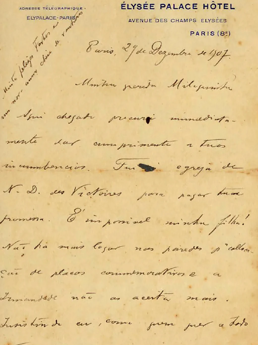 Carta em papel amarelado, manuscrita por Oswaldo à tinta preta, em papel timbrado do Élysée Palace Hotel. Acima, em letras azuis, o nome do hotel e o endereço: “Avenue des Champs Elysées, Paris, 8”. À esquerda, em letras menores: “Adresse Teegraphique – Elypalace – Paris”. No canto superior esquerdo, na diagonal, está escrito por Oswaldo, em letras menores: “Muito felizes fostes e um novo ano cheio de venturas”. Para conhecer o conteúdo das quatro páginas da carta, leia as Cartas de Oswaldo a MIloca.