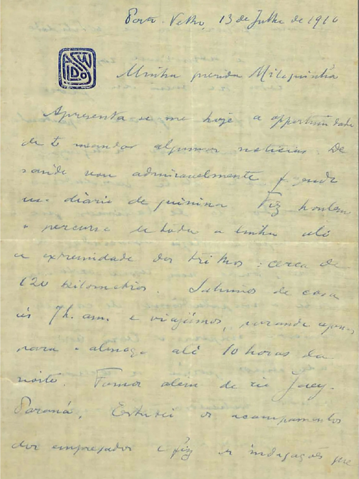 Carta manuscrita de Oswaldo a Miloca, escrita à tinta azul em papel amarelado. No canto superior esquerdo, há um carimbo quadrado e azul, com as letras do nome Oswaldo, embaralhadas e estilizadas. Há vincos na vertical e na horizontal do papel, indicando dobra. No cabeçalho, está escrito: “Porto Velho, 13 de Julho de 1910”.